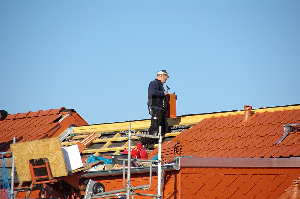 Roland, couvreur au travail sur une toiture en tuiles